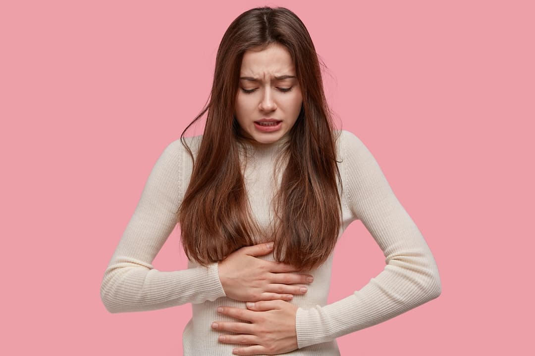 Femme ressentant des douleurs abdominales liées au cycle menstruel